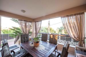 a dining room with a table and chairs on a balcony at Dana's Luxury Maisonette in Volos