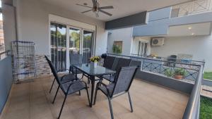 a dining room with a table and chairs on a balcony at Keramoti Luxury Apartments in Keramotí