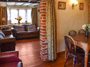 a living room with a brick pillar and a table at Honeysuckle Cottage in Great Yarmouth