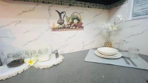 a counter with plates and glasses on a counter top at Zilwest Villa in Flic-en-Flac +2 photos