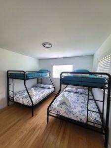 two bunk beds in a room with a wooden floor at Emerald House in Bradenton +17 photos