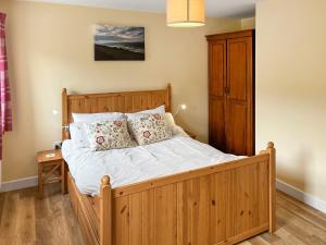 a bedroom with a wooden bed with white sheets and pillows at River View Sanctuary - Uk47338 in Pateley Bridge