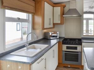 a kitchen with a sink and a stove at Uk47339 - Evergreen in Plumbland
