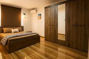 a bedroom with a bed and a large wooden closet at Zilwest Villa in Flic-en-Flac