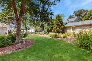 a yard with a tree and a house at Arrowhead Resort in Saugatuck