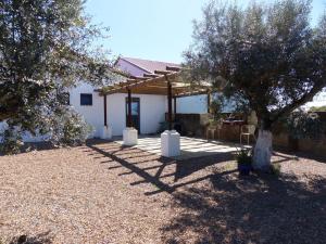 a white house with a pavilion and two trees at Herdade Da Carapuça in Portalegre