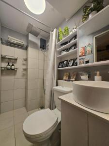 a white bathroom with a toilet and a sink at Zen Vibes Modern 2BR Asian Fusion Stay in Manila