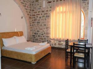 une chambre avec un lit, une table et des chaises dans l'établissement Hotel Guri Shengjin, à Lezhë