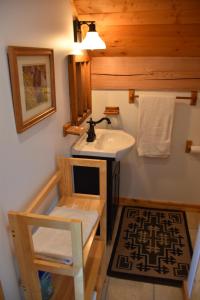 a bathroom with a sink and a mirror and a stool at Seven Sisters Mountains House in Kitwanga
