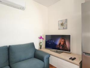 a living room with a blue couch and a tv at La Porta della COSTIERA in Cava deʼ Tirreni