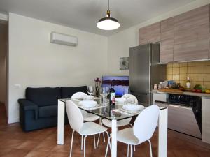 a kitchen with a dining table and white chairs at La Porta della COSTIERA in Cava deʼ Tirreni
