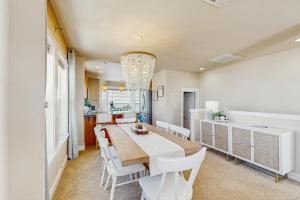 a dining room with a table and white chairs at Alluvial Shores in Rockaway Beach