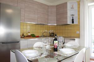 a kitchen with a glass table and white chairs at La Porta della COSTIERA in Cava deʼ Tirreni +58 photos