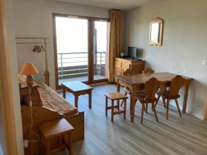 a living room with a table and a couch at Appartement T3 - 3 étoiles - 6 pers - Au pied des pistes in Villarembert