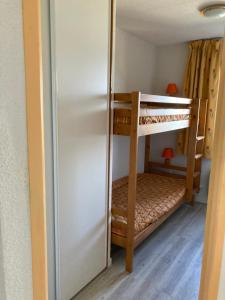a room with two bunk beds and a refrigerator at Appartement T3 - 3 étoiles - 6 pers - Au pied des pistes in Villarembert