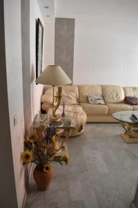 a living room with a couch and a table with a lamp at Le Cyrille in Antibes