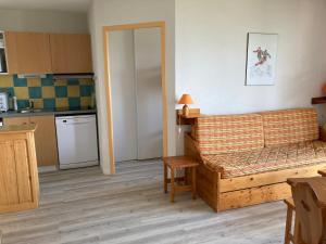 a living room with a couch and a kitchen at Appartement T3 - 3 étoiles - 6 pers - Au pied des pistes in Villarembert
