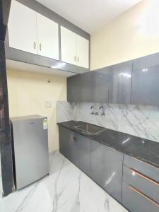 a kitchen with white marble counter tops and a refrigerator at Elegant & Spacious Venue in Kota +13 photos