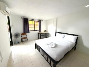 a bedroom with a bed and a desk and a window at Patong Canal Villa R203 in Patong Beach