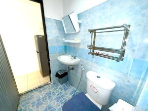 a blue tiled bathroom with a toilet and a sink at Patong Canal Villa R203 in Patong Beach +7 photos