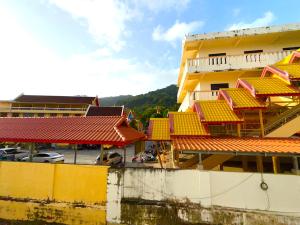 a yellow building with red roofs next to a parking lot at Patong Canal Villa R203 in Patong Beach