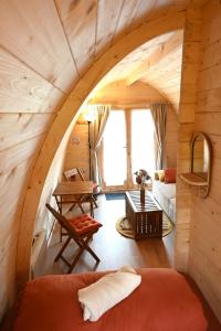 a room in a log cabin with a bed and a table at Pod 4 personnes in Saint-Jacut-les-Pins
