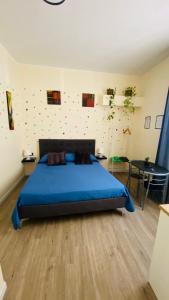 a bedroom with a blue bed and a table at Nel Cuore di Faenza in Faenza