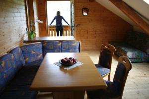 a table and chairs in a room with a woman looking out the window at Graglerhof in Liebenfels