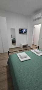 a bedroom with two beds with green sheets and a mirror at DOMUS AISA appartamenti Formia centro in Formia