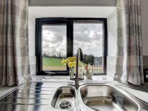 a kitchen sink with a window and flowers on it at 2 Bed in South Molton 88993 in Bishops Nympton +20 photos