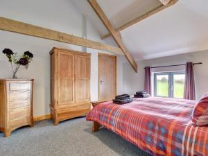a bedroom with a bed and a dresser and a window at 2 Bed in South Molton 88993 in Bishops Nympton