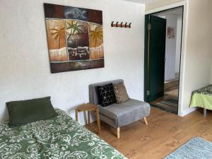 a bedroom with a bed and a chair and a painting at Renthouse Rest & Go Paide in Paide