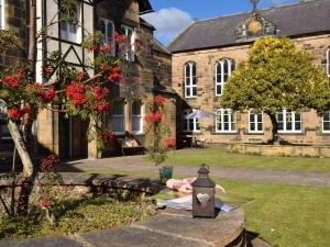 une lampe posée sur une table devant un bâtiment dans l'établissement 5 Bed in Alnwick 60497, à Alnwick