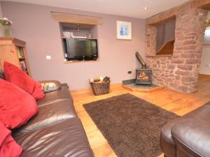 Una sala de estar con un sofá de cuero y una chimenea. en 2 Bed in Dunster 41218, en Timberscombe