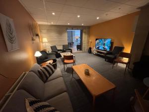 a living room with a couch and a tv at Hotel West in Patreksfjörður