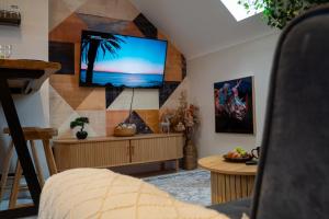 a living room with a flat screen tv on a wall at Upbeat Jungle Loft Apartment in Derby