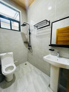 a bathroom with a white toilet and a sink at The Luxe Urban Lounge in Kigali +5 photos