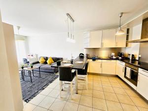 eine Küche und ein Wohnzimmer mit einem Tisch und einer Couch in der Unterkunft City Escape - Cozy 1BR Flat with terrace&parking in Luxemburg (Stadt)