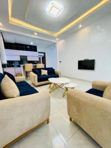 a living room with two couches and a tv at The Luxe Urban Lounge in Kigali