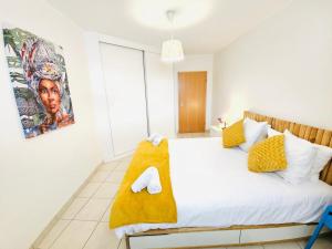 ein Schlafzimmer mit einem Bett mit einer gelben Decke darauf in der Unterkunft City Escape - Cozy 1BR Flat with terrace&parking in Luxemburg (Stadt)