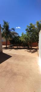 a courtyard with trees and a building and a fence at Casa aconchegante in São Raimundo Nonato