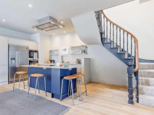 a kitchen with a blue counter and a staircase at 4 Bed in Fowey 82152 in Fowey