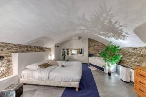 a bedroom with a large bed and a stone wall at Royal Suite Spa et Balnéo Privatif in Lyon
