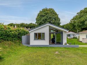 a small white house on top of a grass field at 2 Bed in Brixham 78565 in Brixham