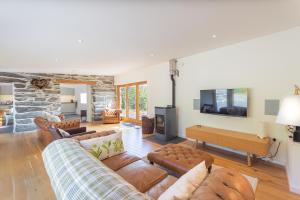 a living room with leather couches and a tv at 3 Bed in Aberdovey DY033 in Aberdyfi