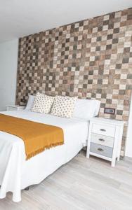 a bedroom with a large white bed and a night stand at Habitación playa gandia in Puerto de Gandía