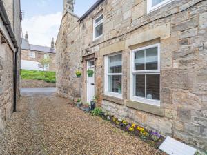 a stone house with a white door and windows at 2 Bed in Rothbury 87902 in Rothbury +10 photos