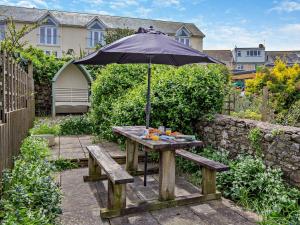 a picnic table with an umbrella in a garden at 2 bed property in Appledore Devon COCKL in Appledore