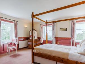 a bedroom with a canopy bed and windows at 4 Bed in Padstow PENDA in Egloshayle +16 photos