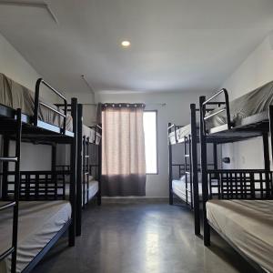 a room with four bunk beds and a window at Vibes Wellness House in Tamanique +26 photos